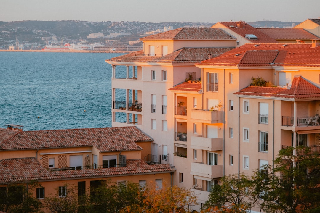 Bloc de apartamente din Romania cu sigla Airbnb pe usa de la intrare si un registru digital pe ecranul telefonului