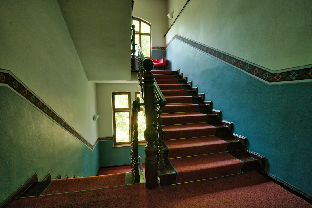 Casa scării a unui bloc vechi, cu geam spart și ușă de acces neetanșă, într-o dimineață geroasă de iarnă