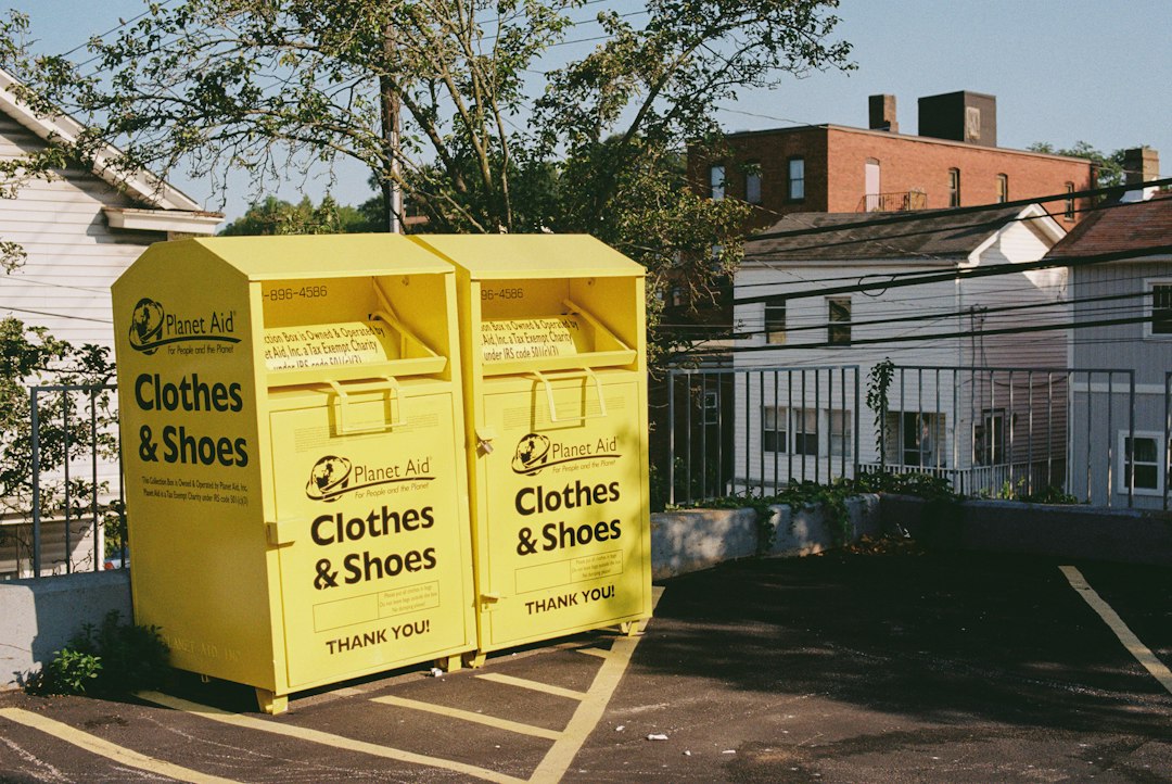Container portocaliu pentru colectarea separată a deșeurilor textile amplasat pe platforma gospodărească a unui bloc de locuințe din România