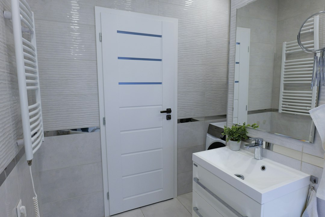 Boiler electric montat în baia unui apartament de bloc, lângă coloana de apă caldă și contorul de apă