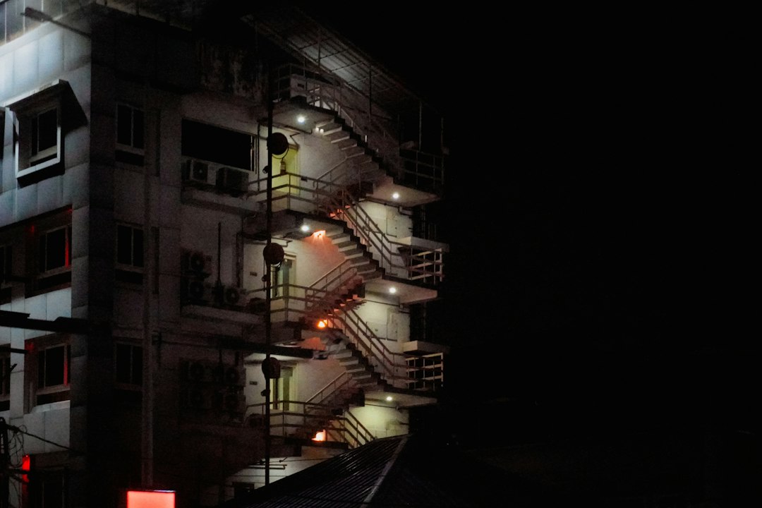 Casa scării a unui bloc de locuințe iluminată seara, cu corp LED cu senzor de mișcare pe palier și tabloul electric de servicii comune