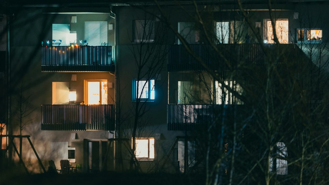 Bloc de locuințe pe timp de iarnă, cu ferestre întunecate în timpul unei pene de curent și casa scării luminată de o lanternă