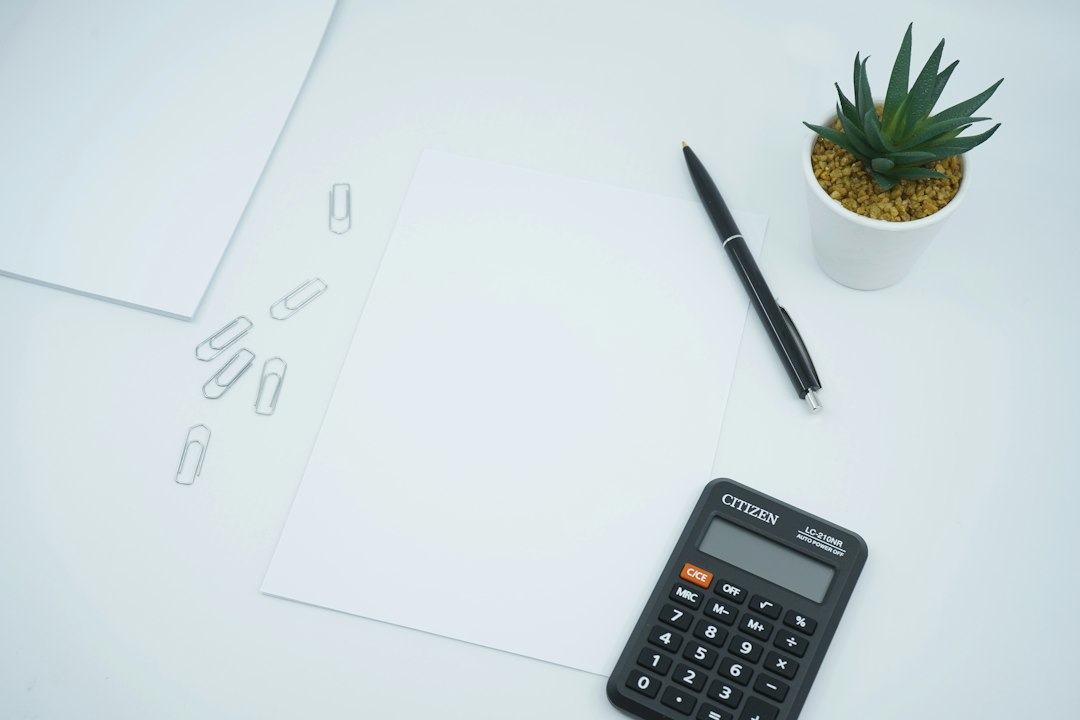 Administrator de bloc și membri ai comitetului executiv analizează bugetul asociației de proprietari în decembrie, cu documente și calculator pe masă