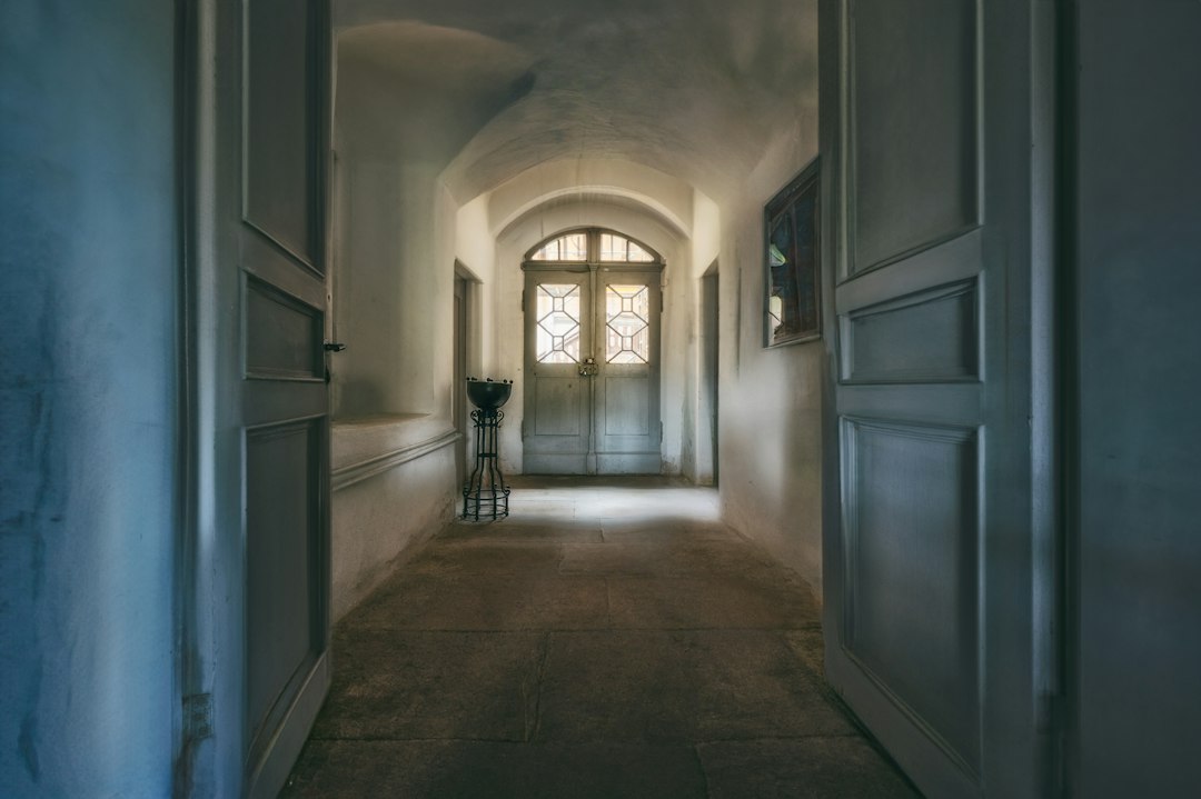 Administrator de bloc și doi vecini în fața unei uși de apartament, cu apă scursă pe palier, întocmind un proces-verbal de constatare a avariei