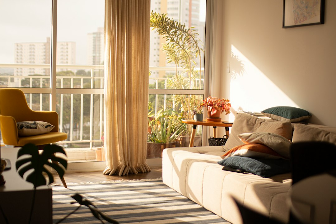 Radiator electric portabil pornit într-un apartament de bloc, lângă un calorifer rece, toamna