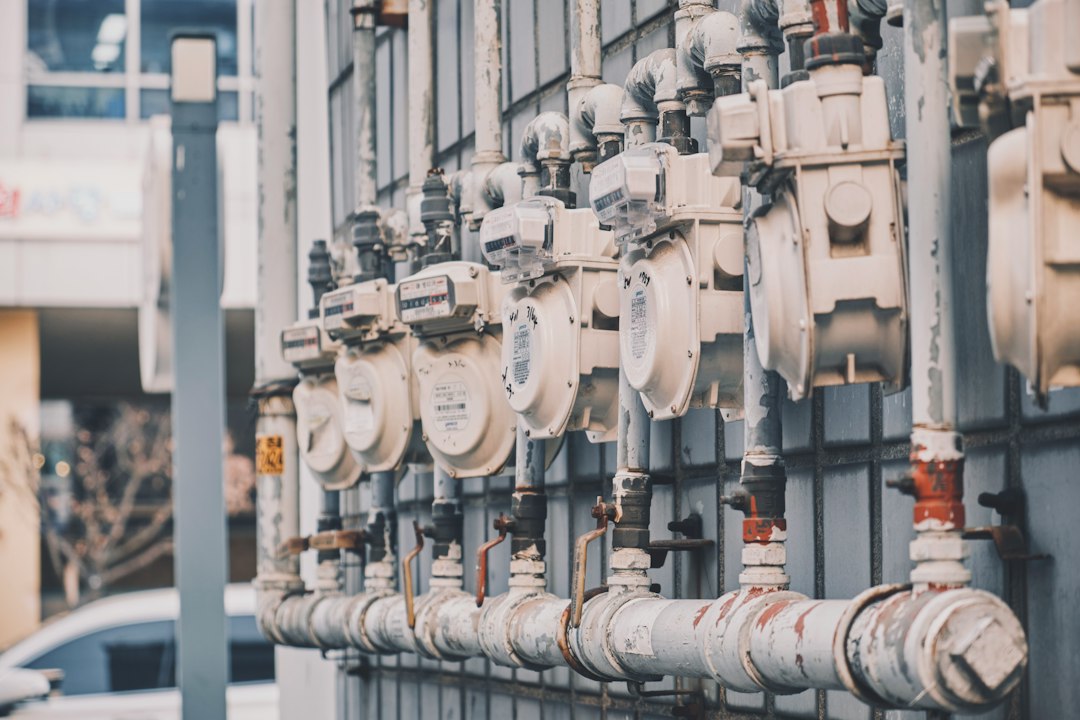 Proprietar dintr-un bloc măsoară temperatura caloriferului cu termometrul și completează o reclamație către operatorul de termoficare