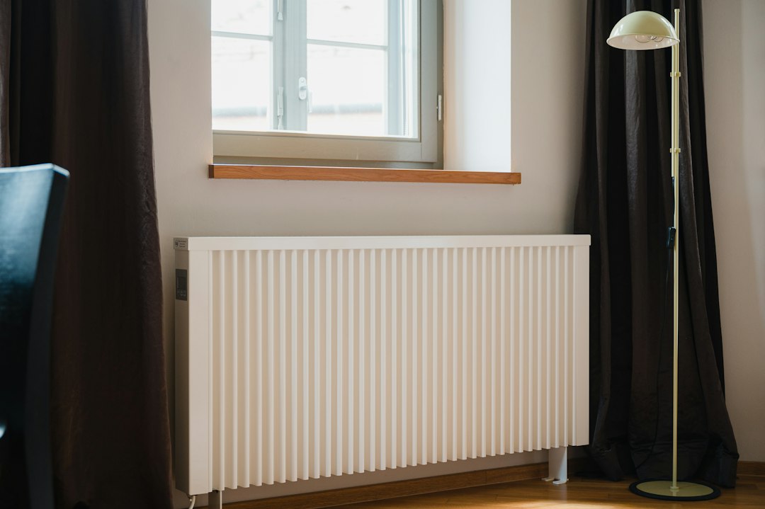 Administrator de asociație verificând o factură de termoficare cu cota de TVA de 11% pe un bloc de apartamente, iarna